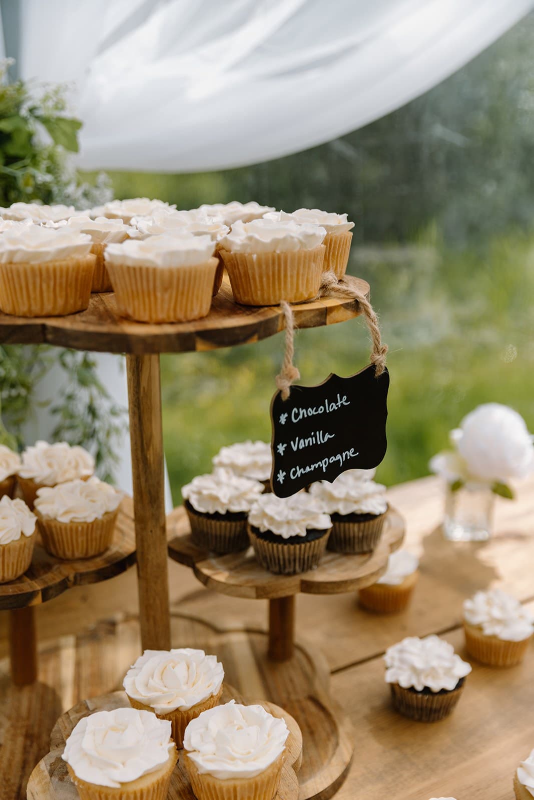 Cupcake display on a rustic wood stand with flavor sign