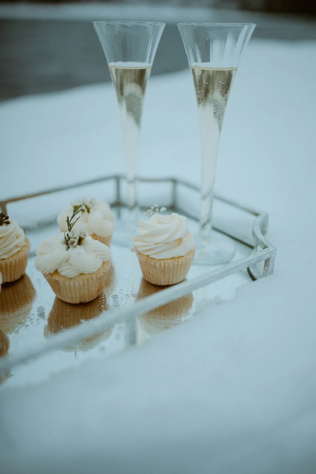 Mini cupcakes with rosemary on a mirrored tray