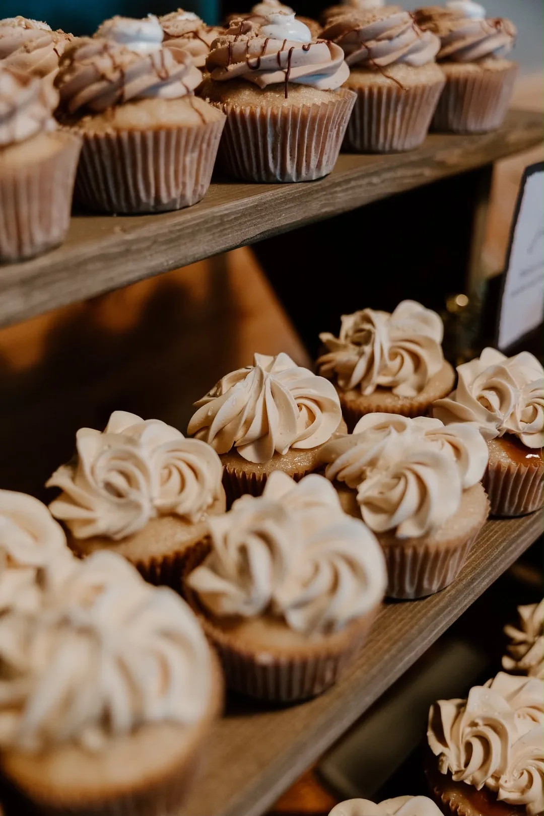 Piped buttercream cupcakes on a wooden stand