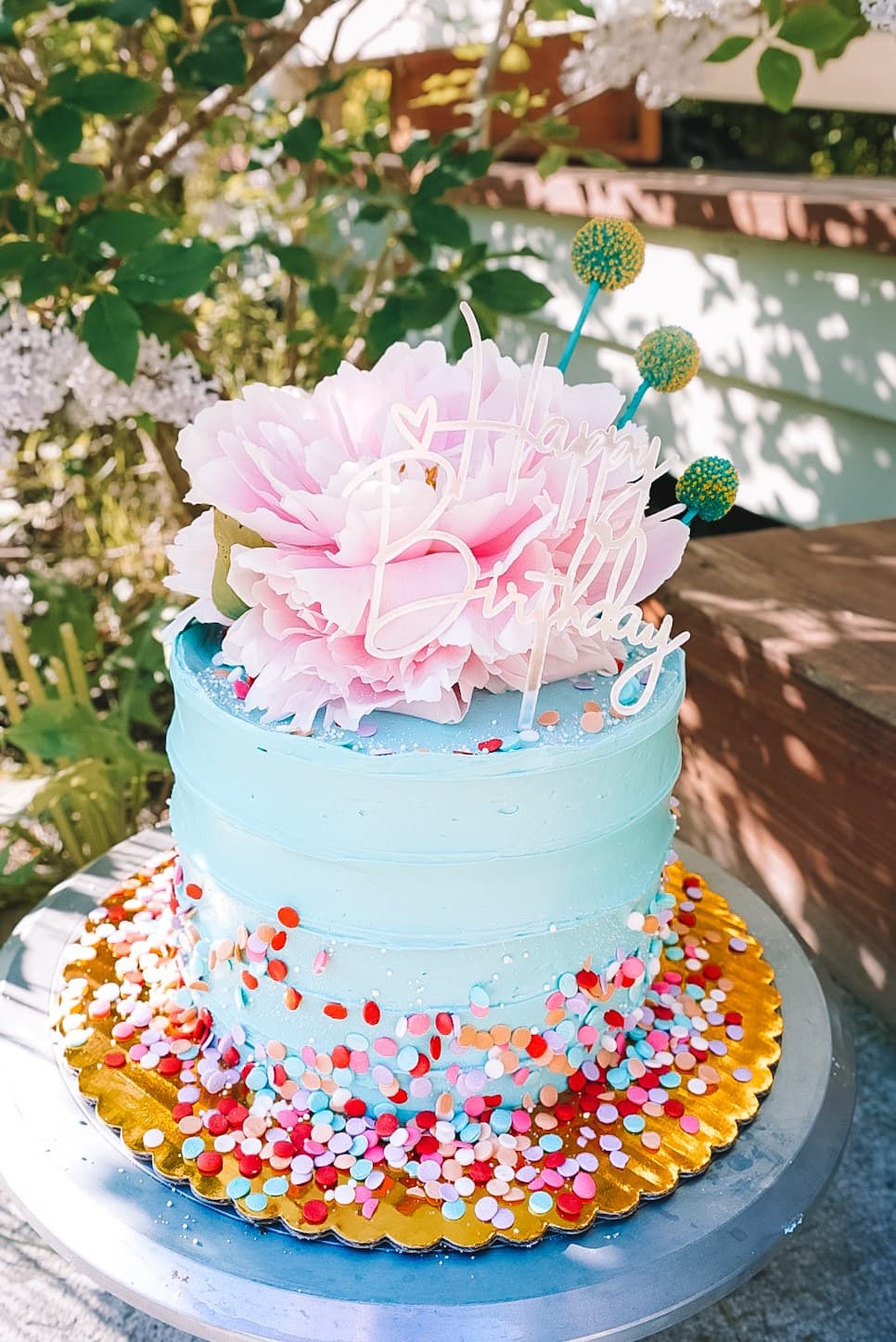 Blue confetti birthday cake with a pink peony