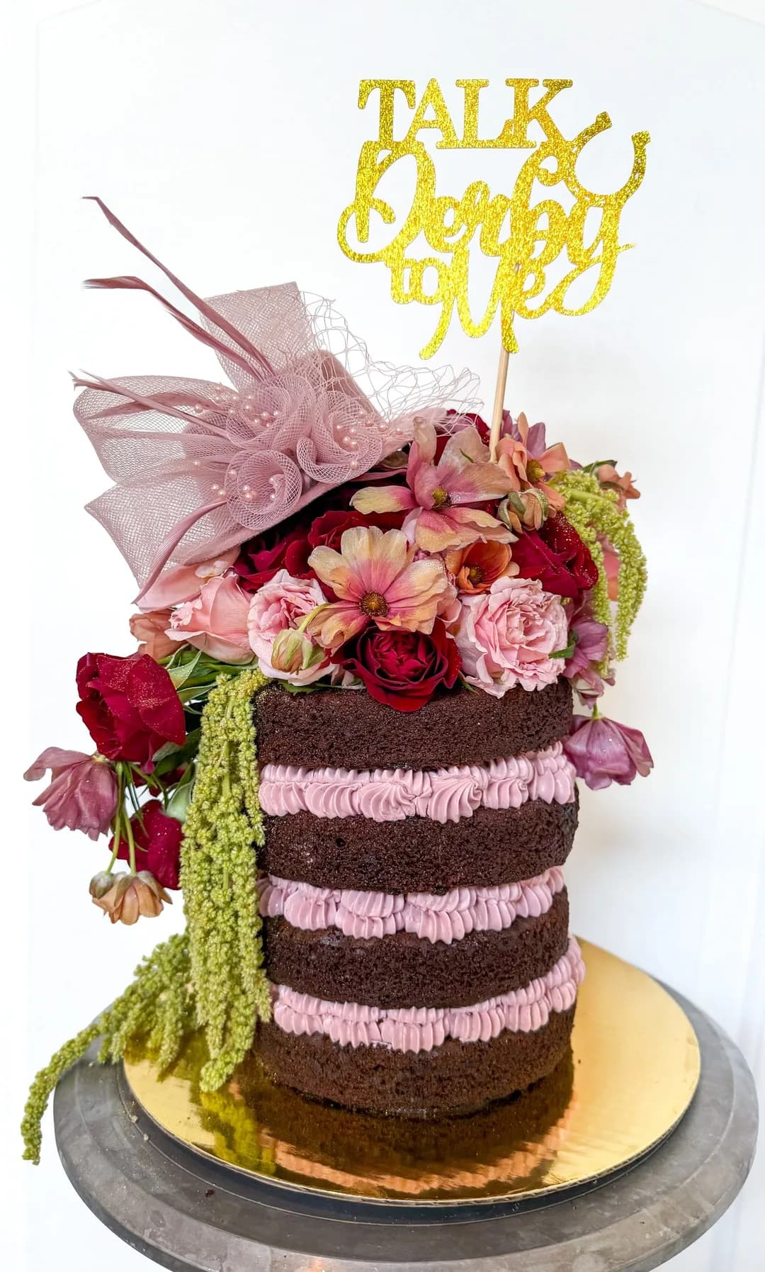 Chocolate naked cake with pink buttercream and fresh roses