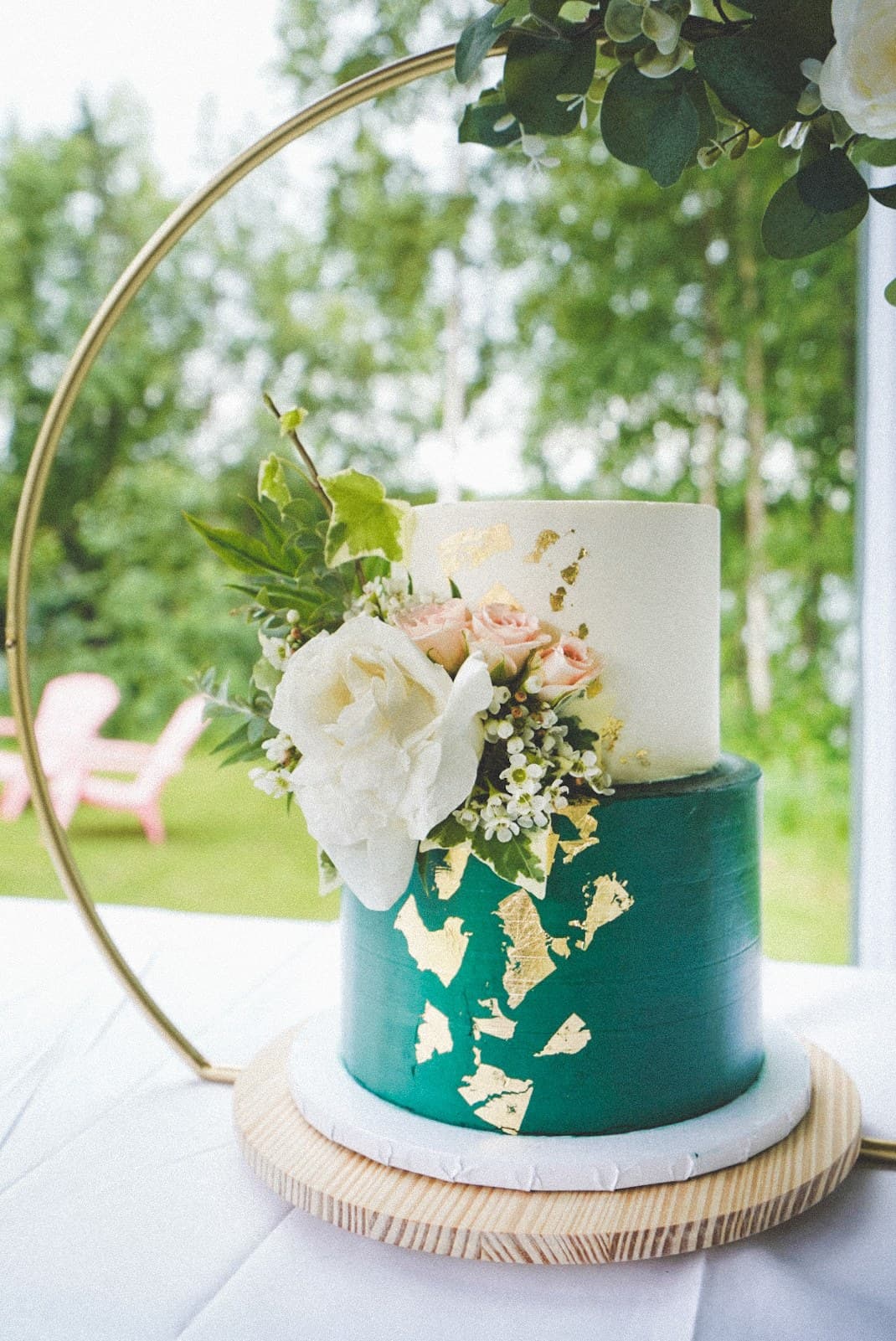Emerald and white wedding cake with gold leaf and white roses