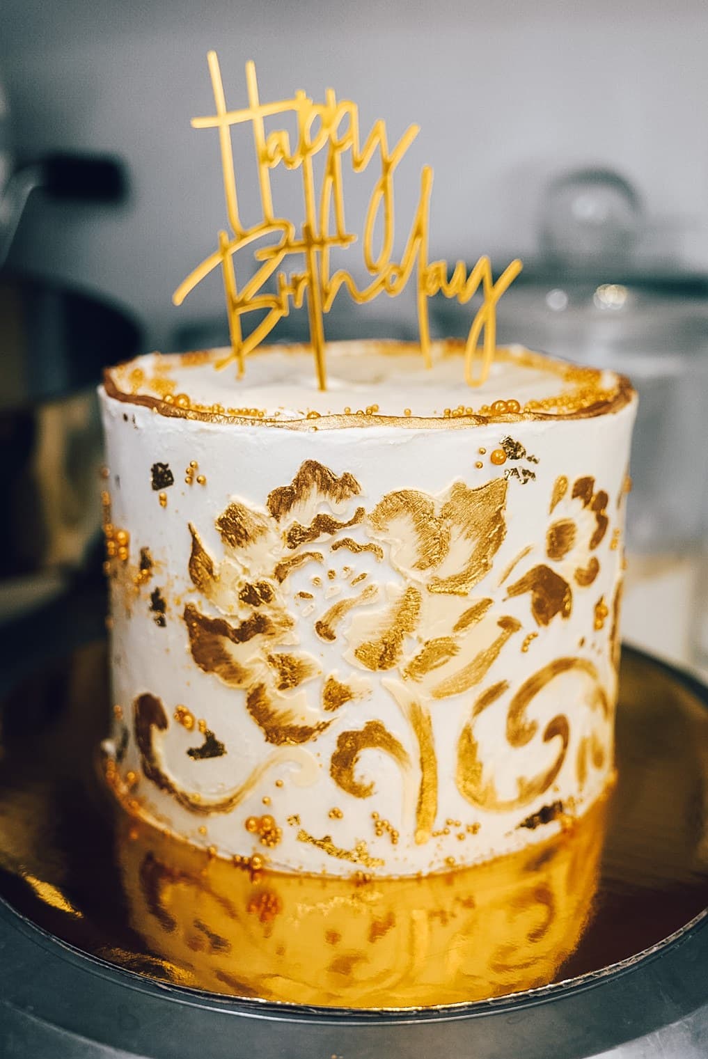 White birthday cake with hand-painted gold florals