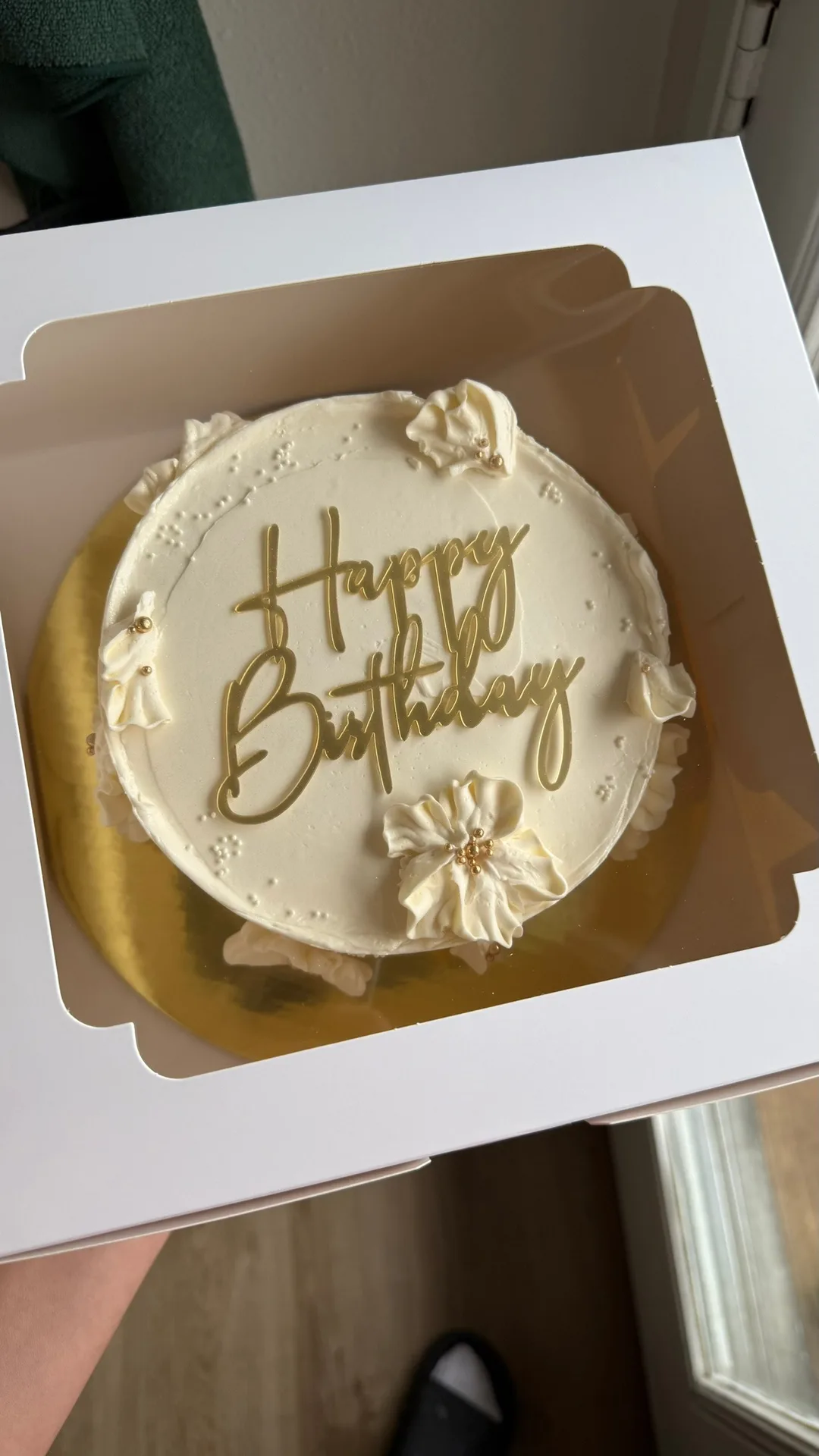 Simple white birthday cake with gold script topper