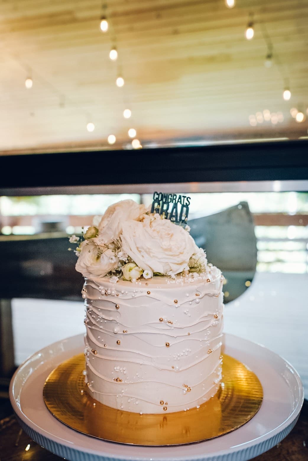 Ribbed buttercream cake with gold pearls and a white rose