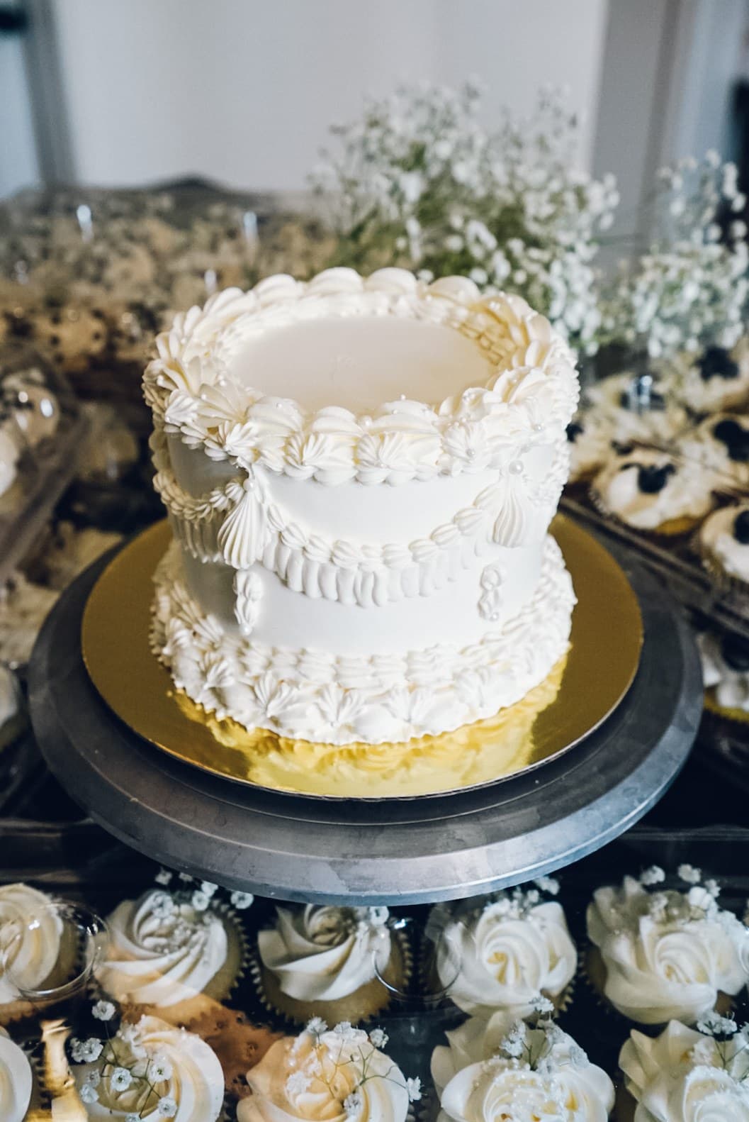 Vintage-piped white buttercream cake on a gold board