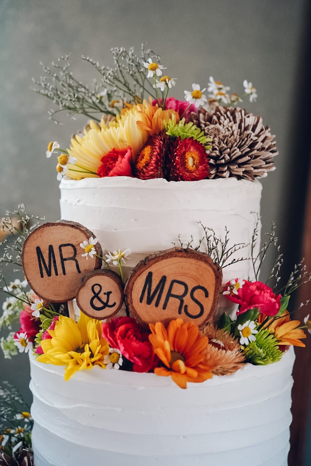 White wedding cake with wood-slice Mr and Mrs signs and fall florals